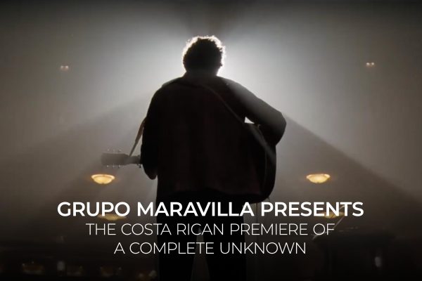 a man with a guitar in a concert hall